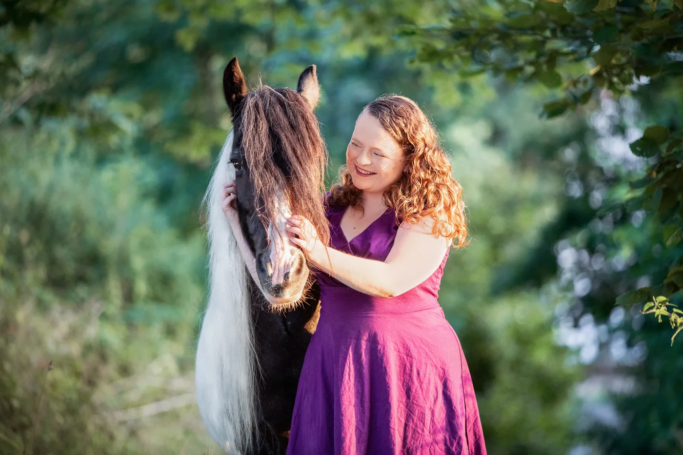 Julia mit ihrem gescheckten Pferd im Abendlicht